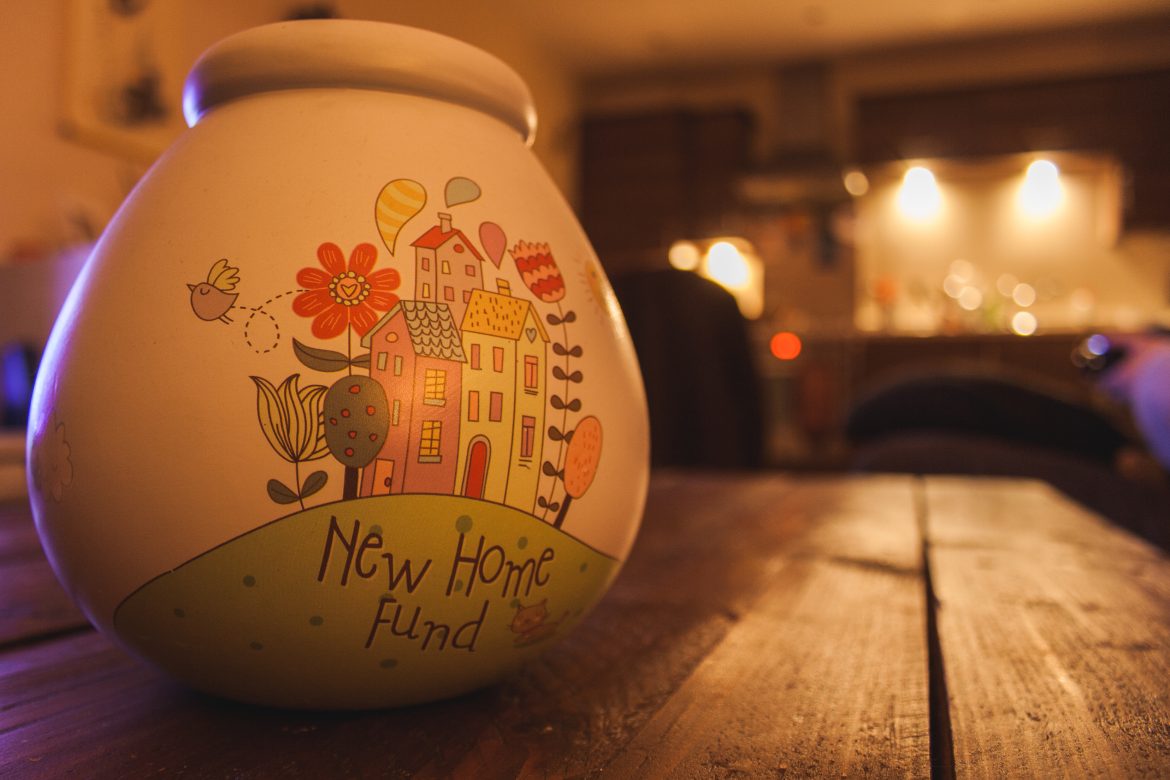 New Home Savings Fund pot sat on a wooden table in a warm comfy house