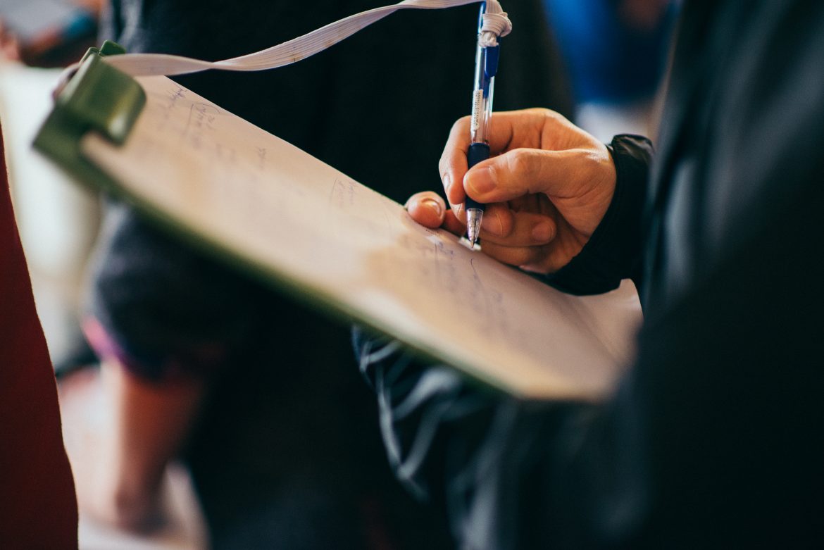 Man Taking Notes on Clipboard